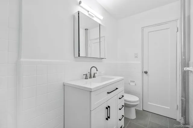 a bathroom with a toilet sink vanity and mirror