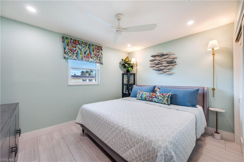 1021 3rd Street South, Unit 310 Naples, FL 34102 - Photo 14 of 20 a bedroom with a large bed and a chandelier