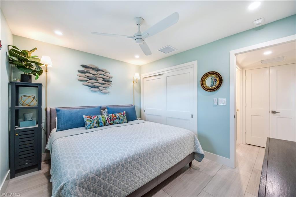 1021 3rd Street South, Unit 310 Naples, FL 34102 - Photo 16 of 20 a bedroom with a bed and a chandelier
