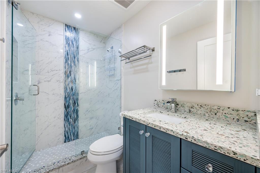 1021 3rd Street South, Unit 310 Naples, FL 34102 - Photo 17 of 20 a bathroom with a granite countertop sink toilet and shower