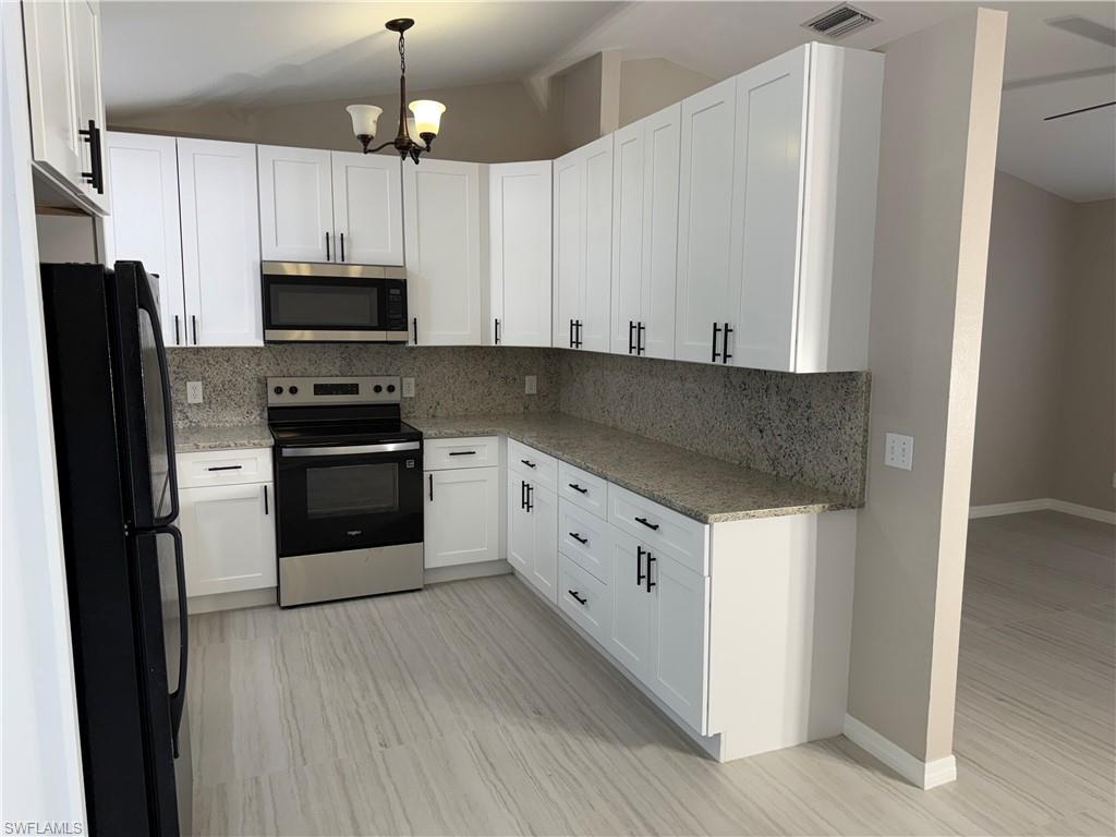 241 8th Street Southeast Naples, FL 34117 - Photo 11 of 50 a kitchen with granite countertop white cabinets and stainless steel appliances
