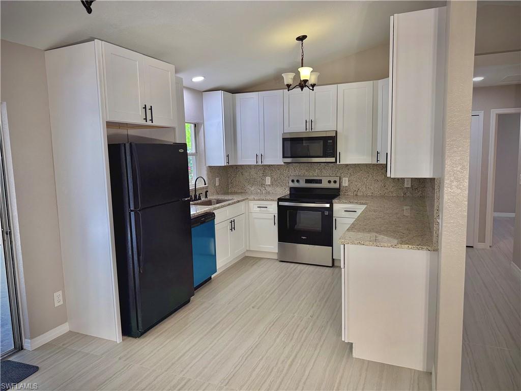 241 8th Street Southeast Naples, FL 34117 - Photo 12 of 50 a kitchen with a refrigerator a sink and cabinets