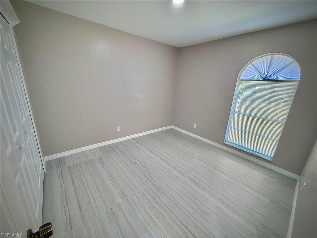 241 8th Street Southeast Naples, FL 34117 - Photo 25 of 50 an empty room with wooden floor and windows