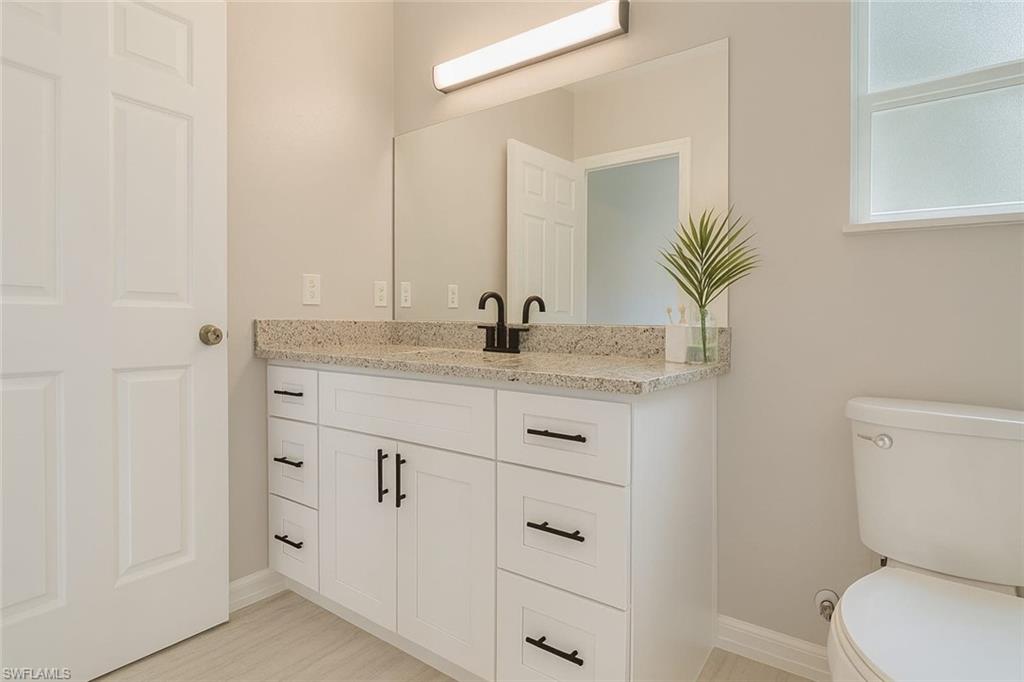 241 8th Street Southeast Naples, FL 34117 - Photo 30 of 50 a bathroom with a granite countertop sink and a mirror