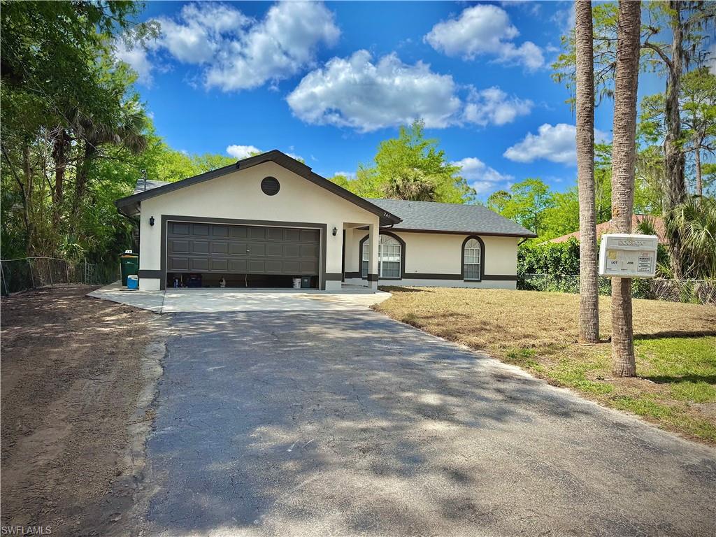 241 8th Street Southeast Naples, FL 34117 - Photo 3 of 50 a front view of a house with a yard and garage