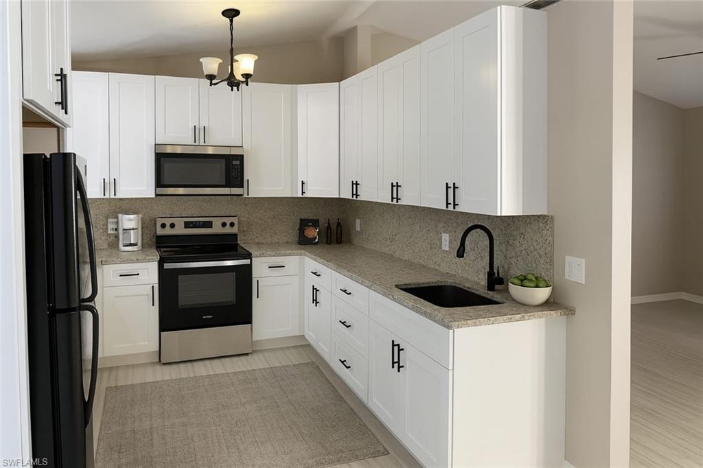 241 8th Street Southeast Naples, FL 34117 - Photo 36 of 50 a kitchen with stainless steel appliances kitchen island granite countertop a sink and a refrigerator