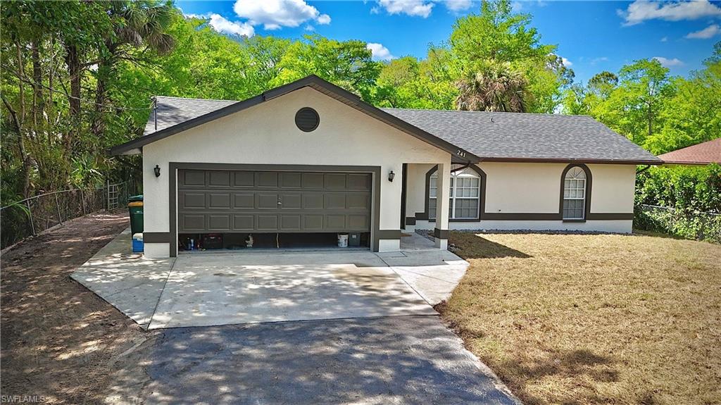 241 8th Street Southeast Naples, FL 34117 - Photo 4 of 50 a front view of a house with a yard