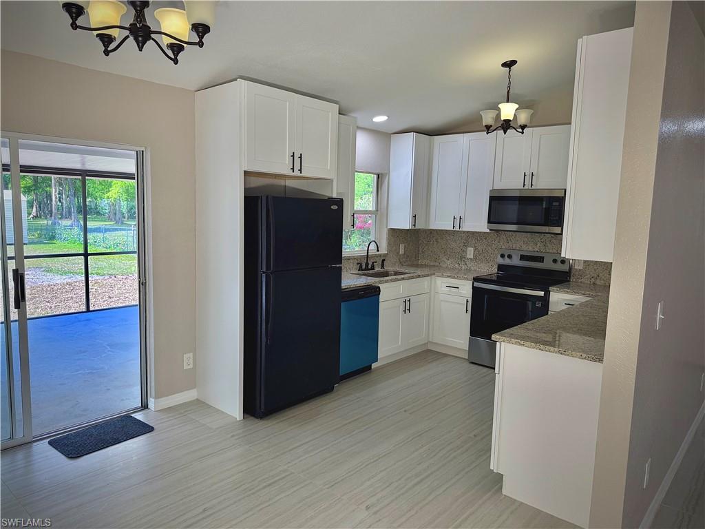 241 8th Street Southeast Naples, FL 34117 - Photo 10 of 50 a kitchen with a refrigerator and a stove top oven