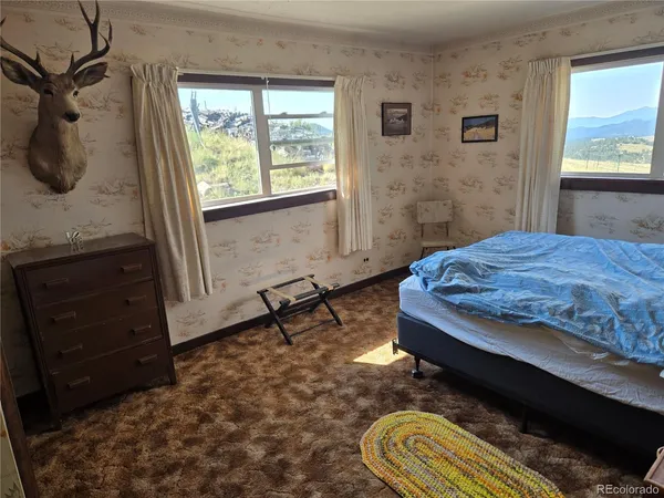 a bedroom with a bed and a dresser next to a window