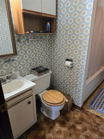 a bathroom with a toilet sink and mirror