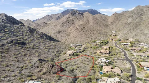 a view of a dry field with mountains in the background