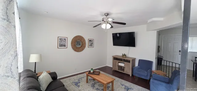 a living room with furniture a flat screen tv and a lamp