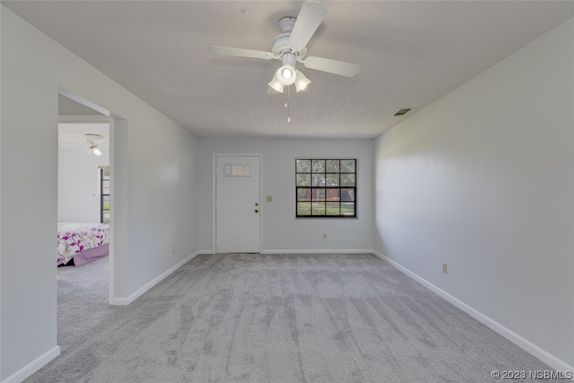 404 Sea Gull Court Edgewater, FL 32141 - Photo 11 of 28 an empty room with windows and ceiling fan