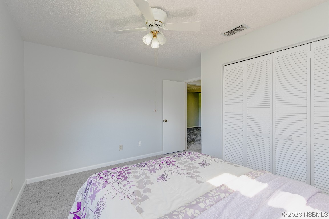 404 Sea Gull Court Edgewater, FL 32141 - Photo 19 of 28 a bedroom with a bed and a chandelier