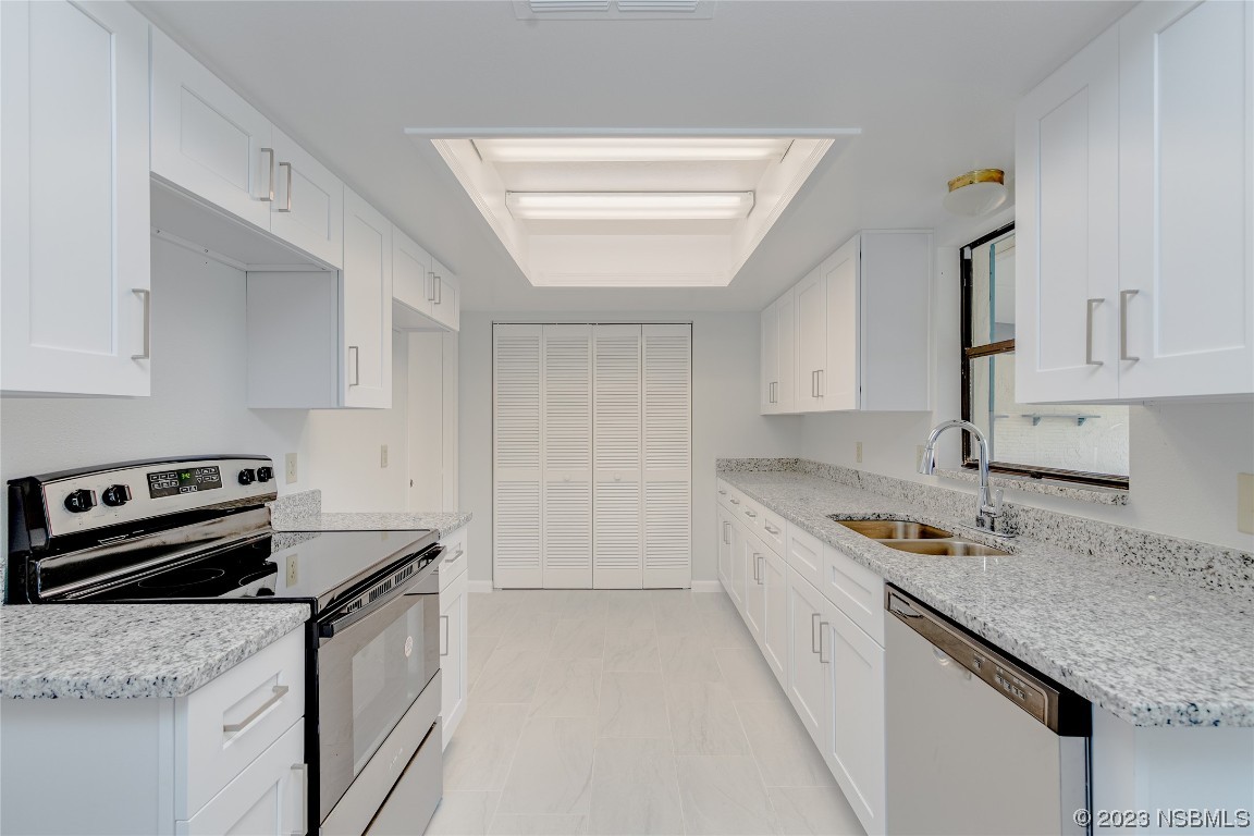 404 Sea Gull Court Edgewater, FL 32141 - Photo 7 of 28 a kitchen with a stove sink and cabinets