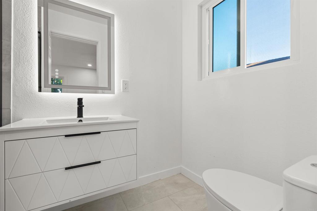 1708 Harold Road Escondido, CA 92026 - Photo 16 of 40 a bathroom with a toilet a sink and mirror