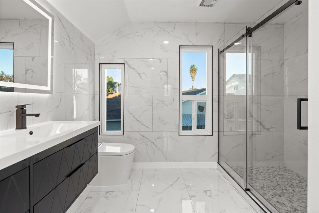 1708 Harold Road Escondido, CA 92026 - Photo 31 of 40 a bathroom with a double vanity sink toilet and shower