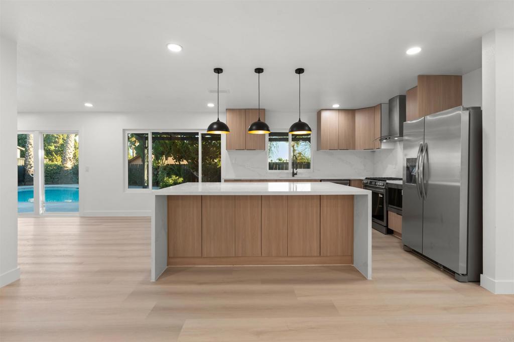 1708 Harold Road Escondido, CA 92026 - Photo 7 of 40 a kitchen with stainless steel appliances kitchen island granite countertop a refrigerator and a sink