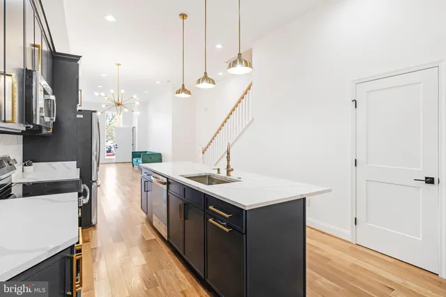 a kitchen with a sink a stove and a wooden floor