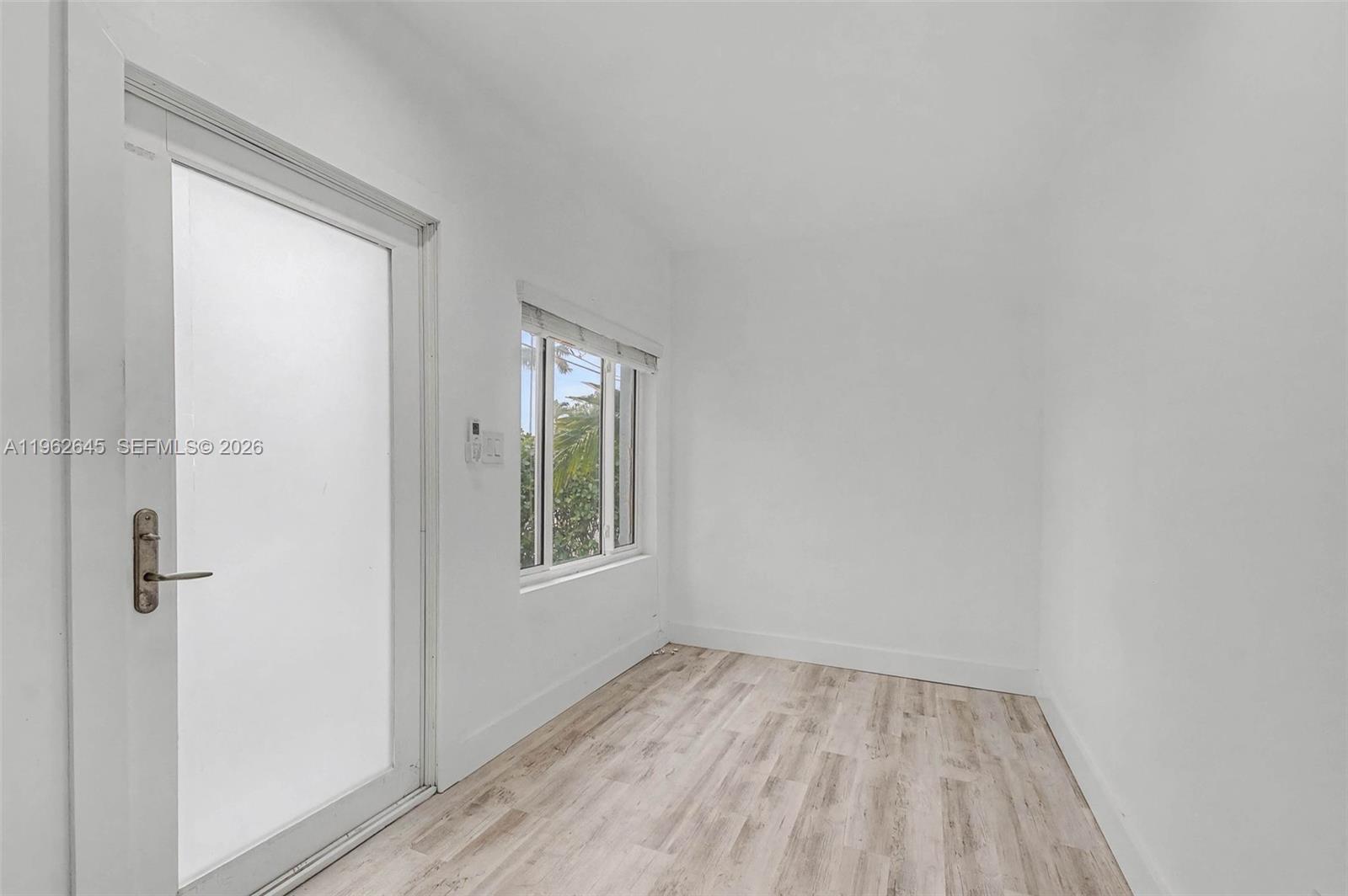 2900 Southwest 4th Street Miami, FL 33135 - Photo 16 of 18 a view of an empty room with wooden floor and a window