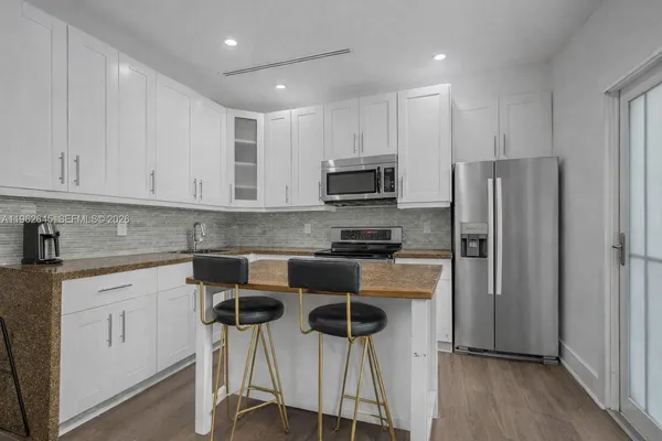 a kitchen with stainless steel appliances granite countertop a refrigerator and a stove top oven