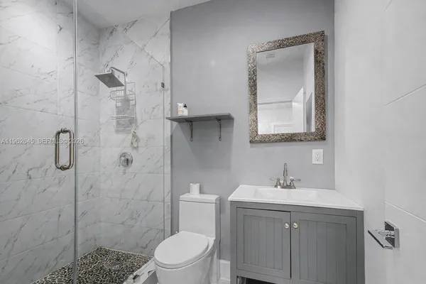 a bathroom with a sink a toilet and shower