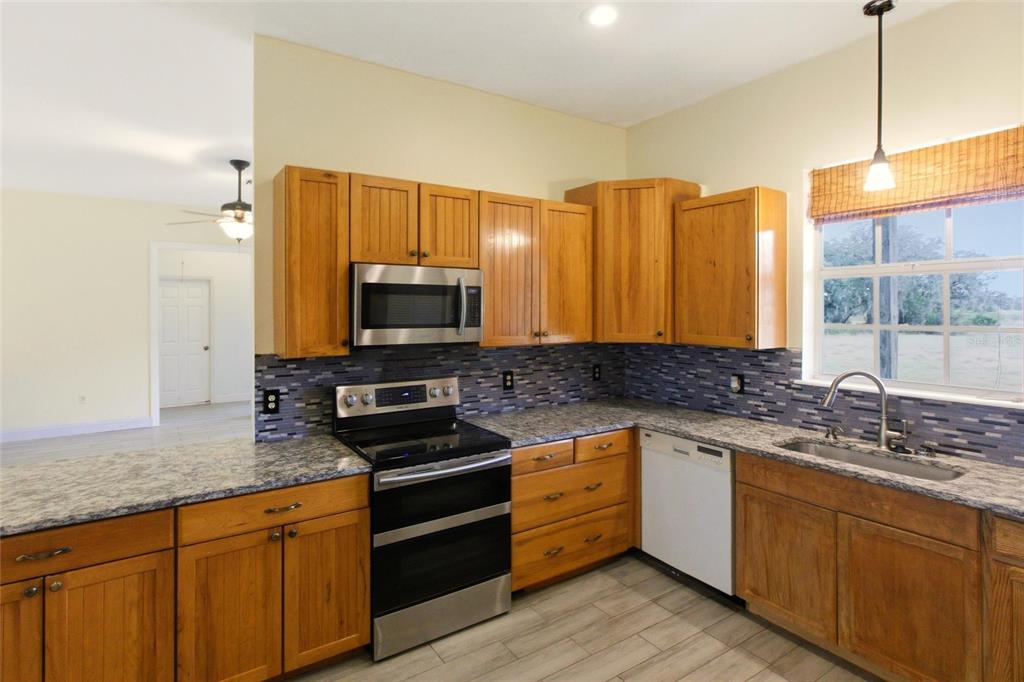 1841 State Rte 66 Zolfo Springs, FL 33890 - Photo 11 of 34 a kitchen with stainless steel appliances a sink cabinets and wooden floor