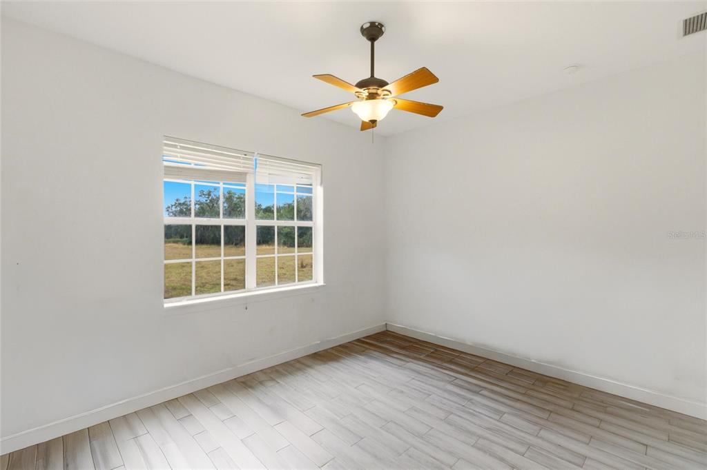 1841 State Rte 66 Zolfo Springs, FL 33890 - Photo 19 of 34 a view of empty room with wooden floor and fan