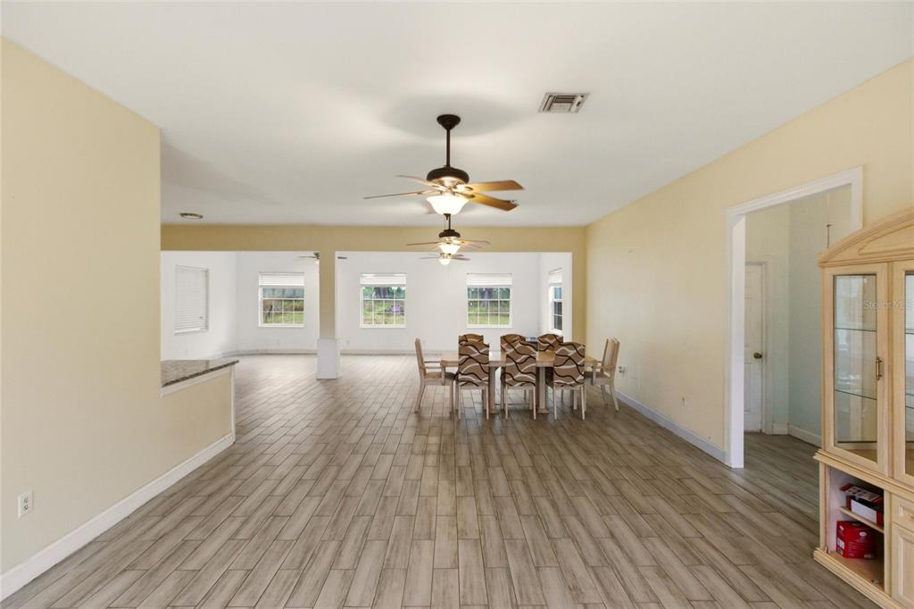 1841 State Rte 66 Zolfo Springs, FL 33890 - Photo 5 of 34 a dining room with wooden floor a chandelier a glass table and chairs