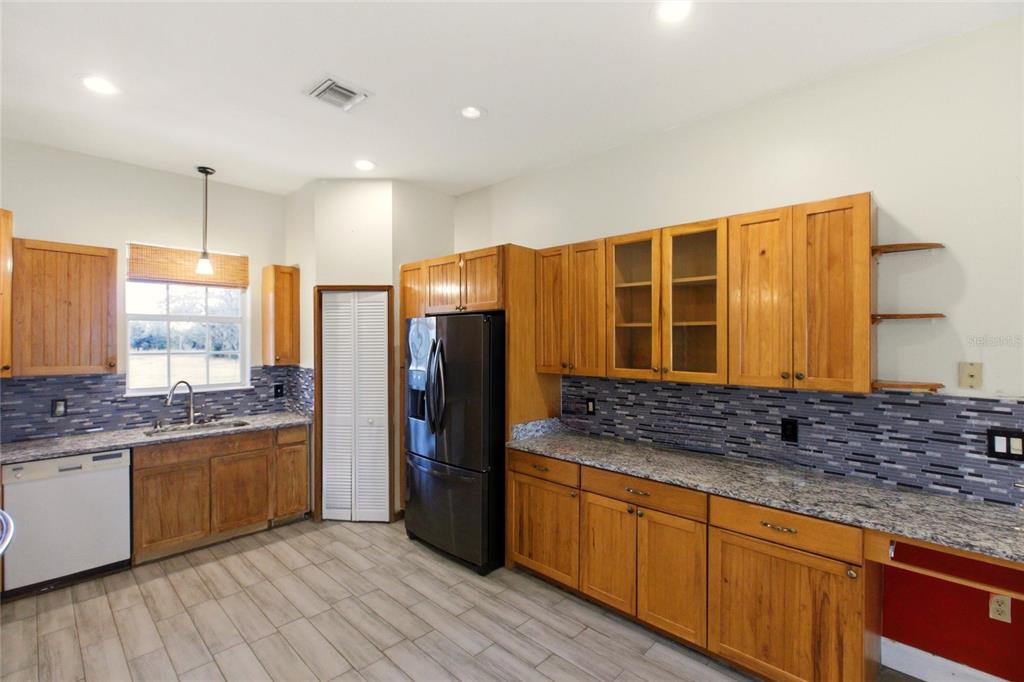 1841 State Rte 66 Zolfo Springs, FL 33890 - Photo 10 of 34 a kitchen with stainless steel appliances granite countertop a sink stove and refrigerator