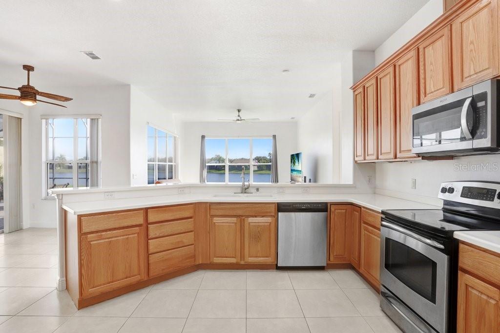 699 Glendora Road Kissimmee, FL 34759 - Photo 20 of 56 a large kitchen with stainless steel appliances granite countertop a stove sink and cabinets