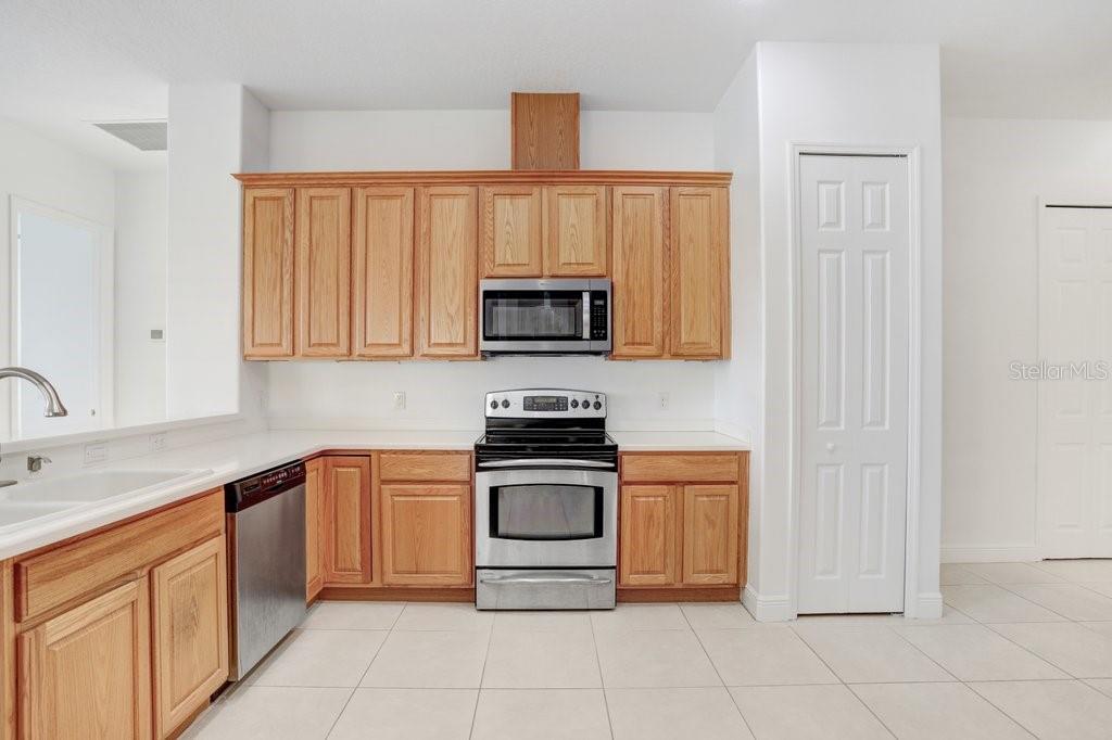 699 Glendora Road Kissimmee, FL 34759 - Photo 21 of 56 a kitchen with stainless steel appliances granite countertop white cabinets and a stove top oven