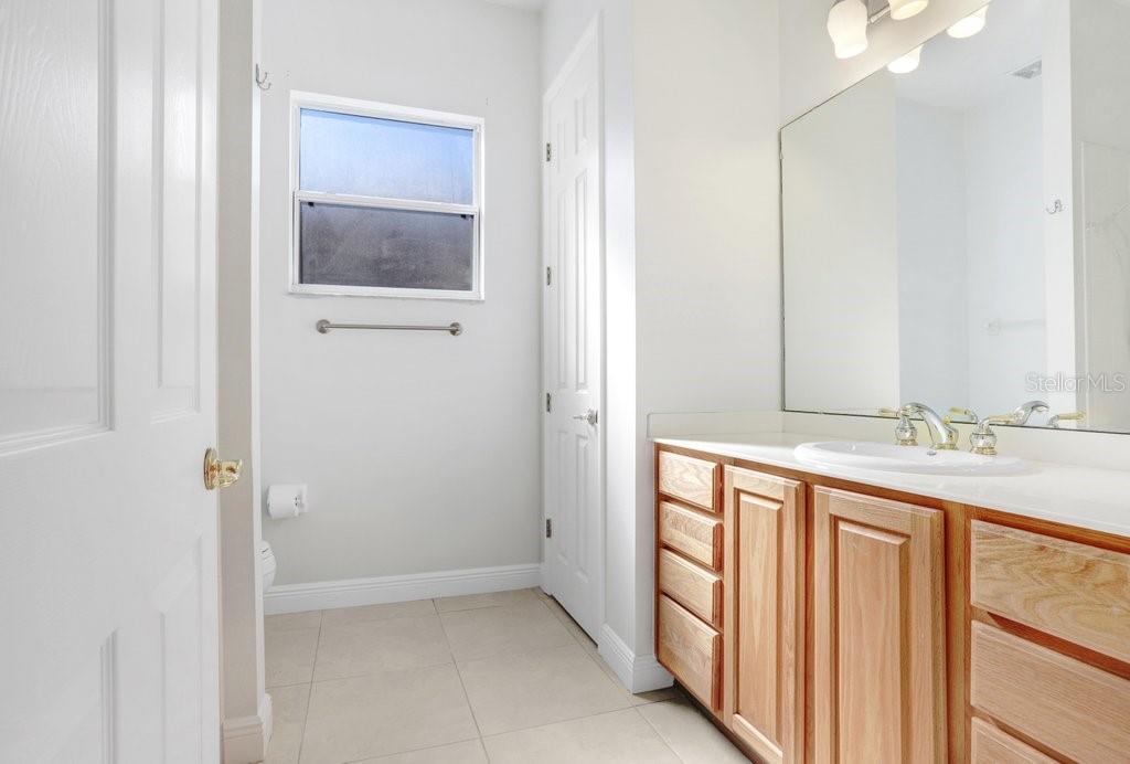 699 Glendora Road Kissimmee, FL 34759 - Photo 28 of 56 a bathroom with a double vanity sink and a mirror