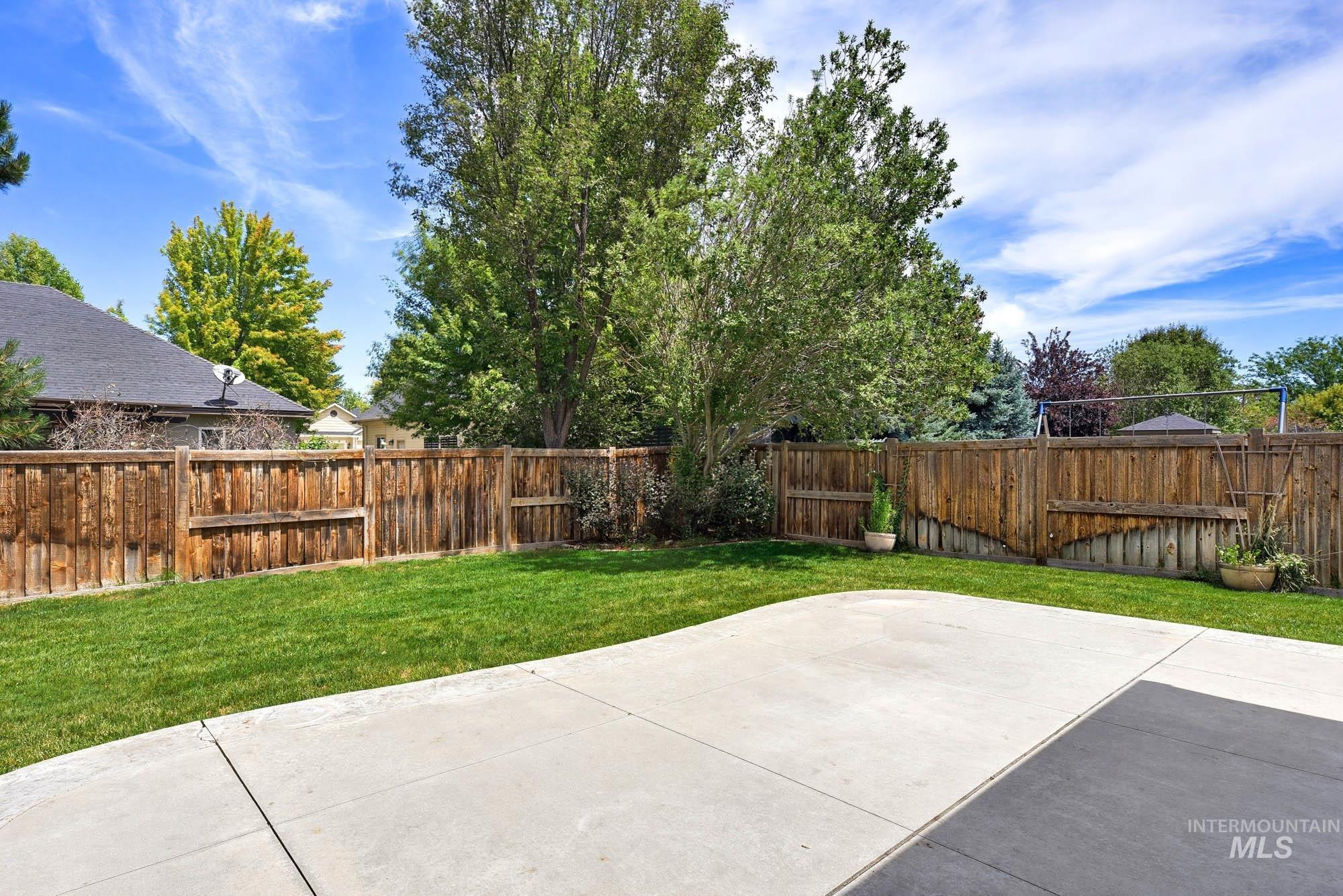 2172 West Cedar Grove Street Meridian, ID 83646 - Photo 37 of 49 Expansive backyard featuring a manicured lawn, a large concrete patio, and mature trees