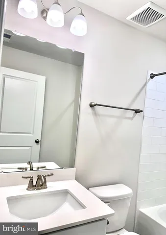 a bathroom with a sink a toilet a mirror and shower