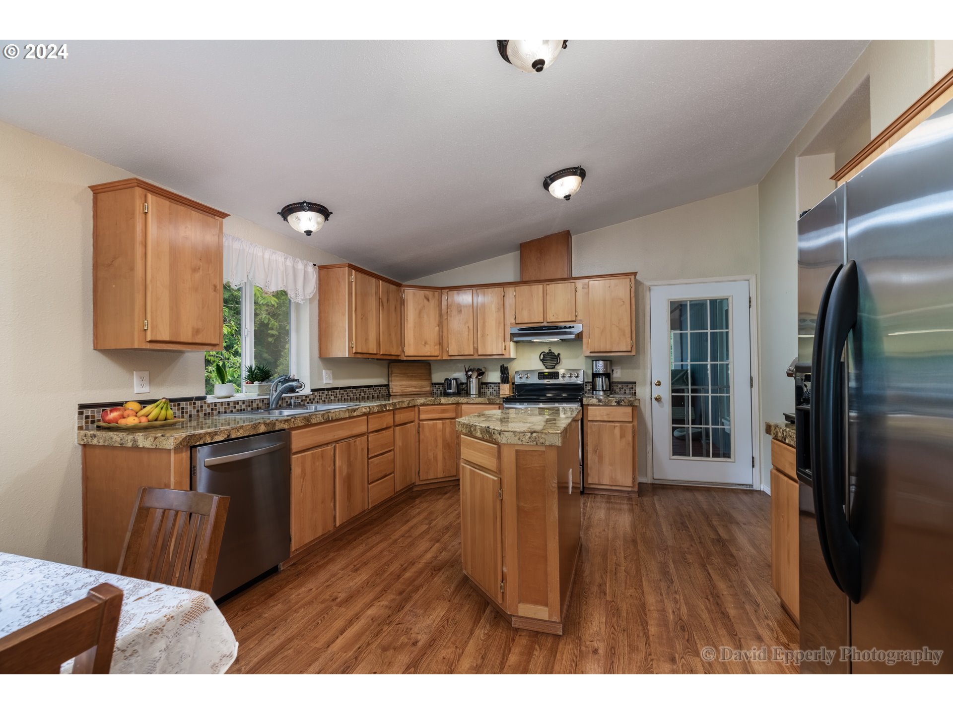 24534 Warren Road Rainier, OR 97048 - Photo 8 of 34 a kitchen with stainless steel appliances granite countertop a refrigerator a sink dishwasher a stove and white countertops with wooden floor
