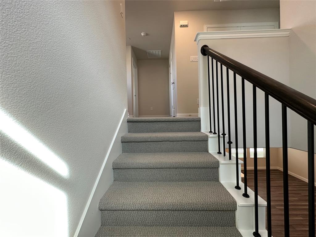 123 Monarch Way Wylie, TX 75098 - Photo 18 of 36 a view of staircase with lots of frames on wall