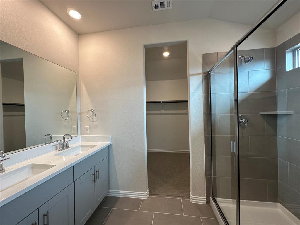 123 Monarch Way Wylie, TX 75098 - Photo 32 of 36 a bathroom with a double vanity sink a mirror and a shower