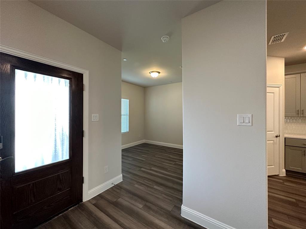 123 Monarch Way Wylie, TX 75098 - Photo 5 of 36 a view of a hallway with wooden floor and a living room
