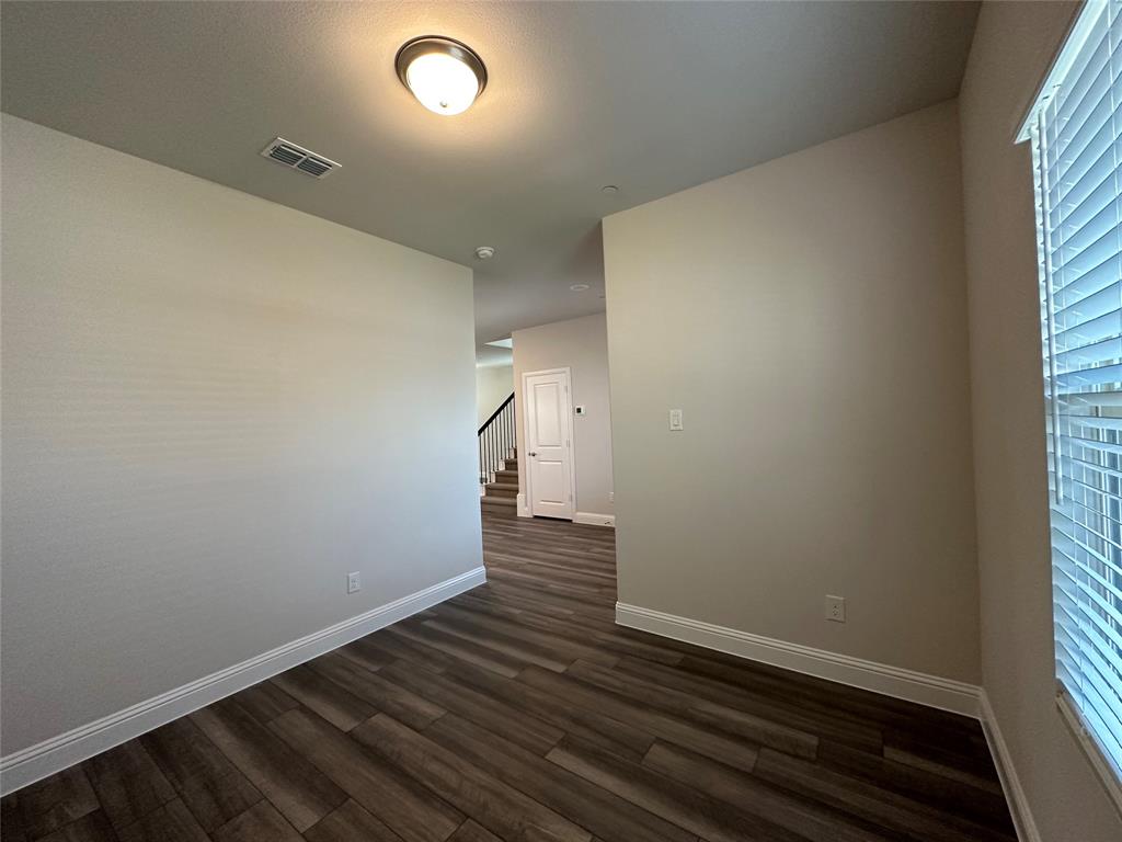123 Monarch Way Wylie, TX 75098 - Photo 7 of 36 an empty room with wooden floor and windows