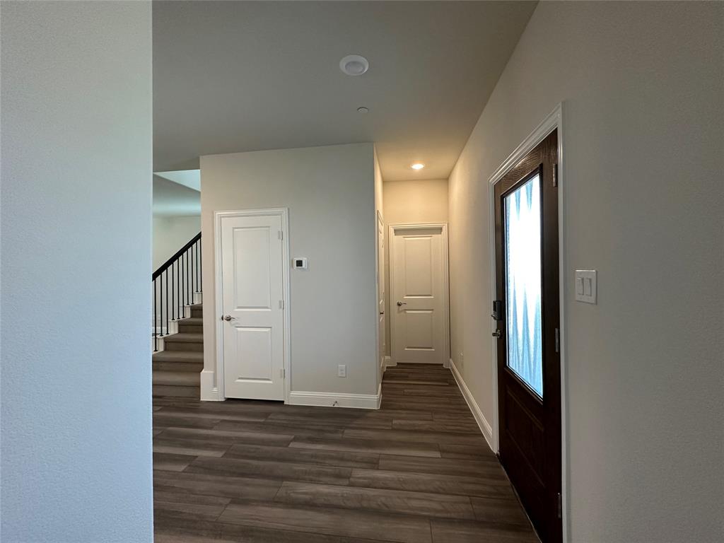 123 Monarch Way Wylie, TX 75098 - Photo 8 of 36 a view of a hallway with wooden floor and staircase