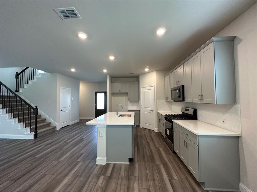123 Monarch Way Wylie, TX 75098 - Photo 10 of 36 a kitchen with stainless steel appliances sink refrigerator and microwave