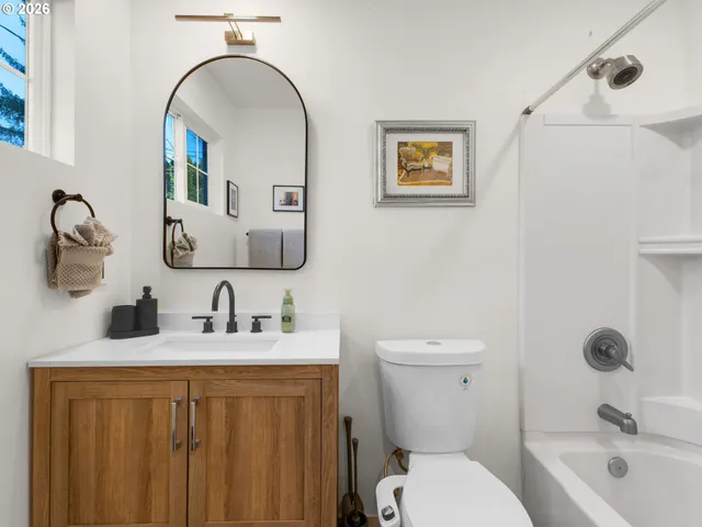a bathroom with a toilet a sink and mirror