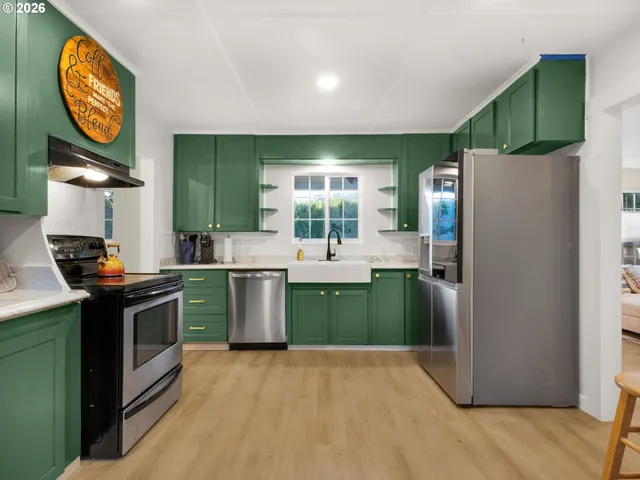 a kitchen with kitchen island a refrigerator a sink a stove and a refrigerator