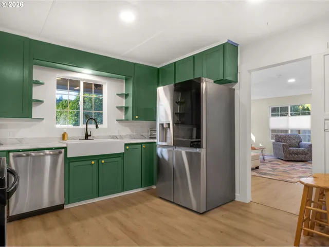 a kitchen with stainless steel appliances granite countertop a refrigerator and a sink
