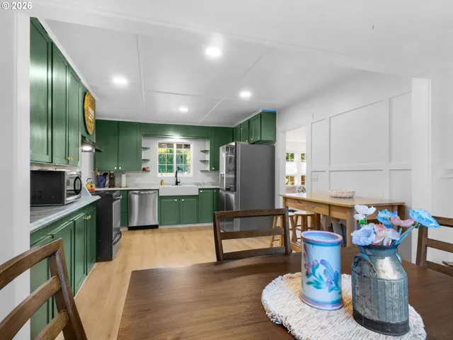 a kitchen with a refrigerator and a wooden floor
