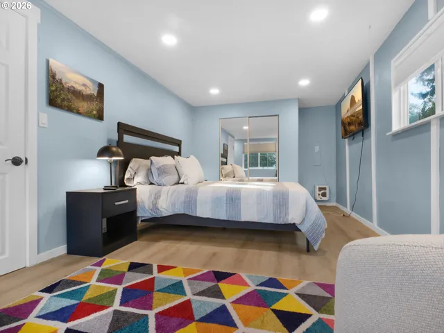 a bedroom with a bed and painting on the wall