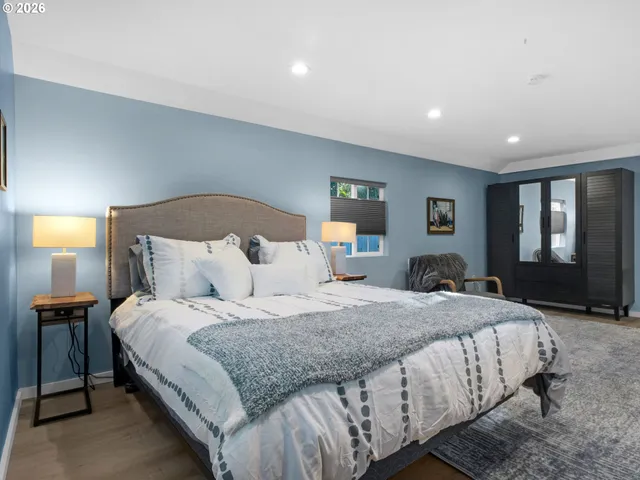 a bedroom with a large bed and a night stand