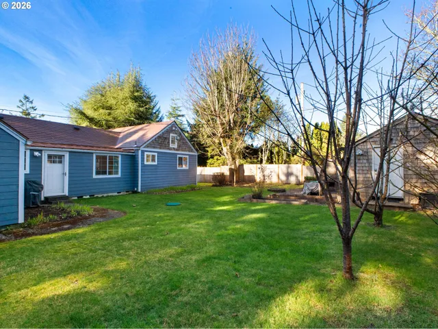a view of a yard in front of a house with large tree