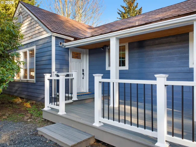 a view of a house with wooden deck and furniture